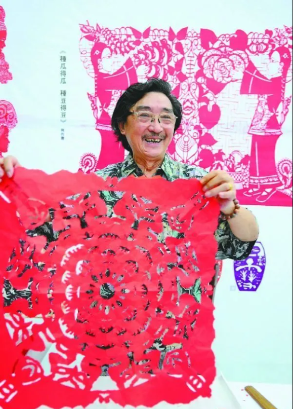 剪纸传承人何作霖展示仪陇剪纸艺术。