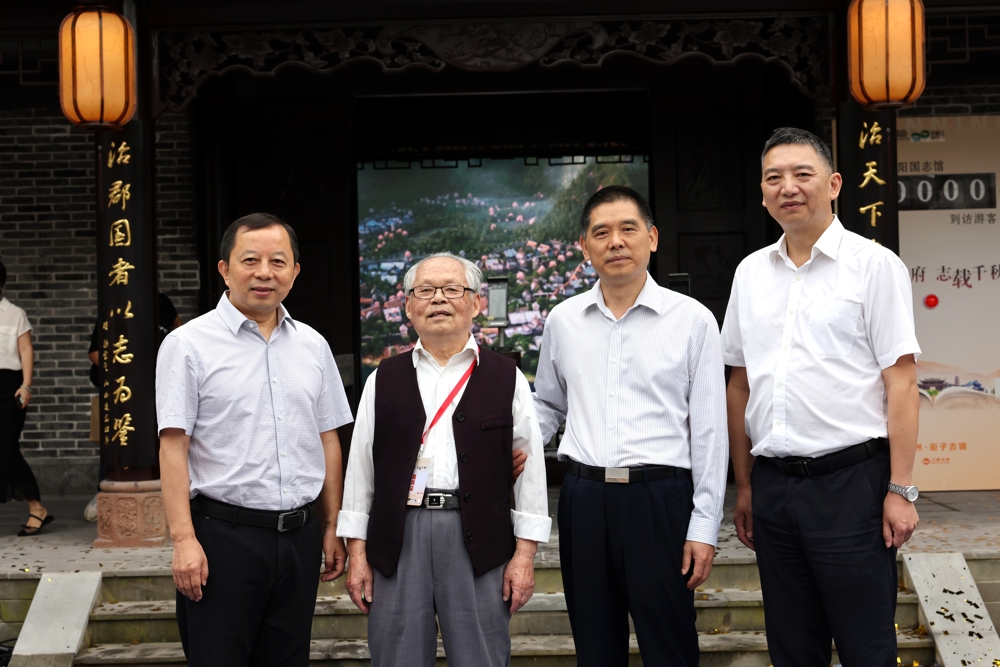 2025年9月28日，陈建春（右二）、马海军（左一，成都市地方志办主任）、丁强武（右一，崇州市地方志办主任）与93岁的地方志专家张伯龄（左二）在华阳国志馆开馆仪式上合影）